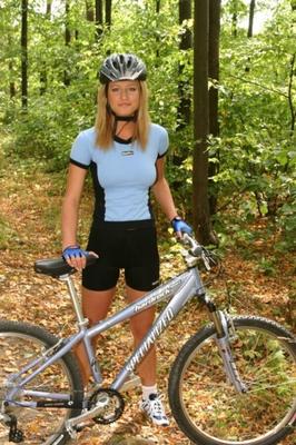 Laura loira na floresta com bicicleta