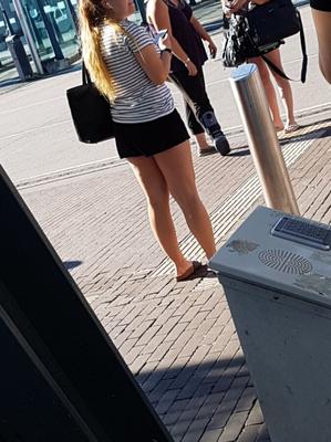 Blondine in kurzen schwarzen Shorts und Birkenstocks wartet